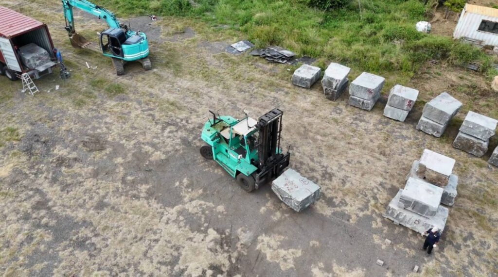 柬埔寨台商林家民董事長捐贈20個貨櫃的花崗石材進行卸櫃作業